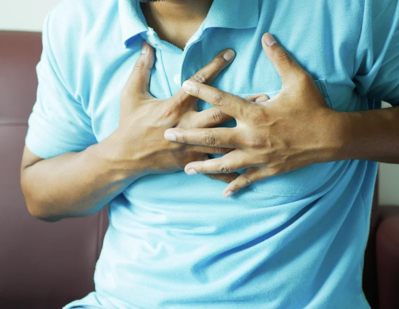 Man clutching his chest, indicating heart pain or discomfort - Towfiqu barbhuiya (pexels.com) HealthServ